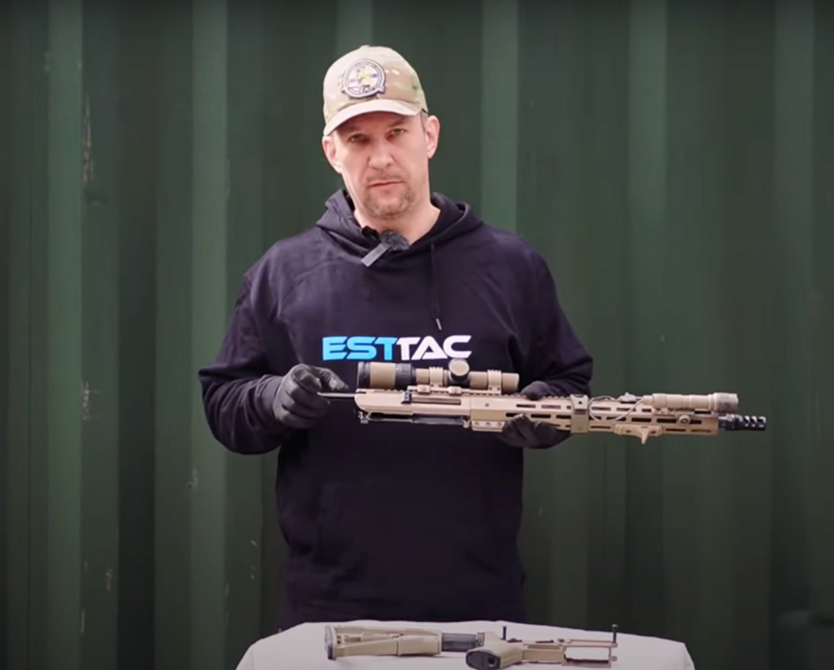 Instructor holding an AR-15 upper assembly during a maintenance demonstration
