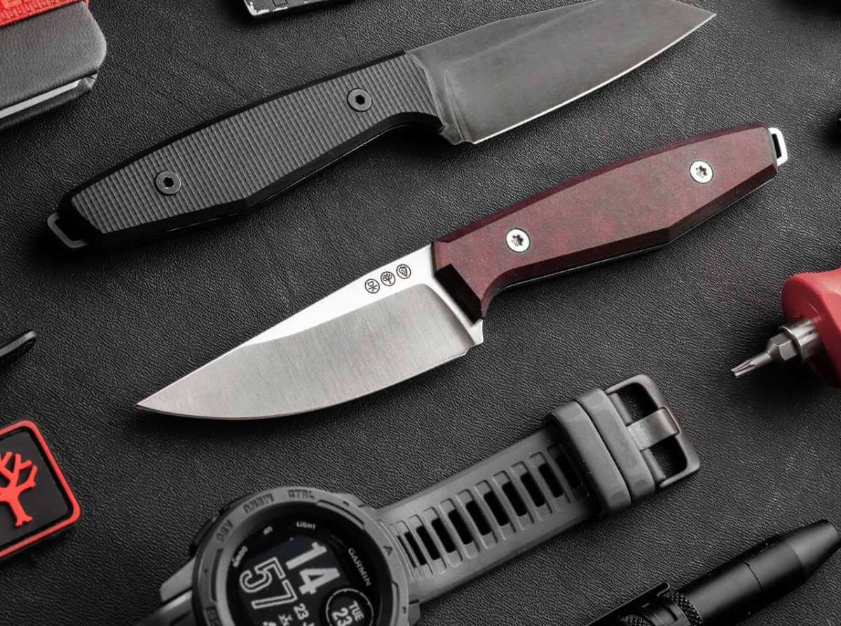 Fixed Blade Knived laying on a table with other tactical accessories