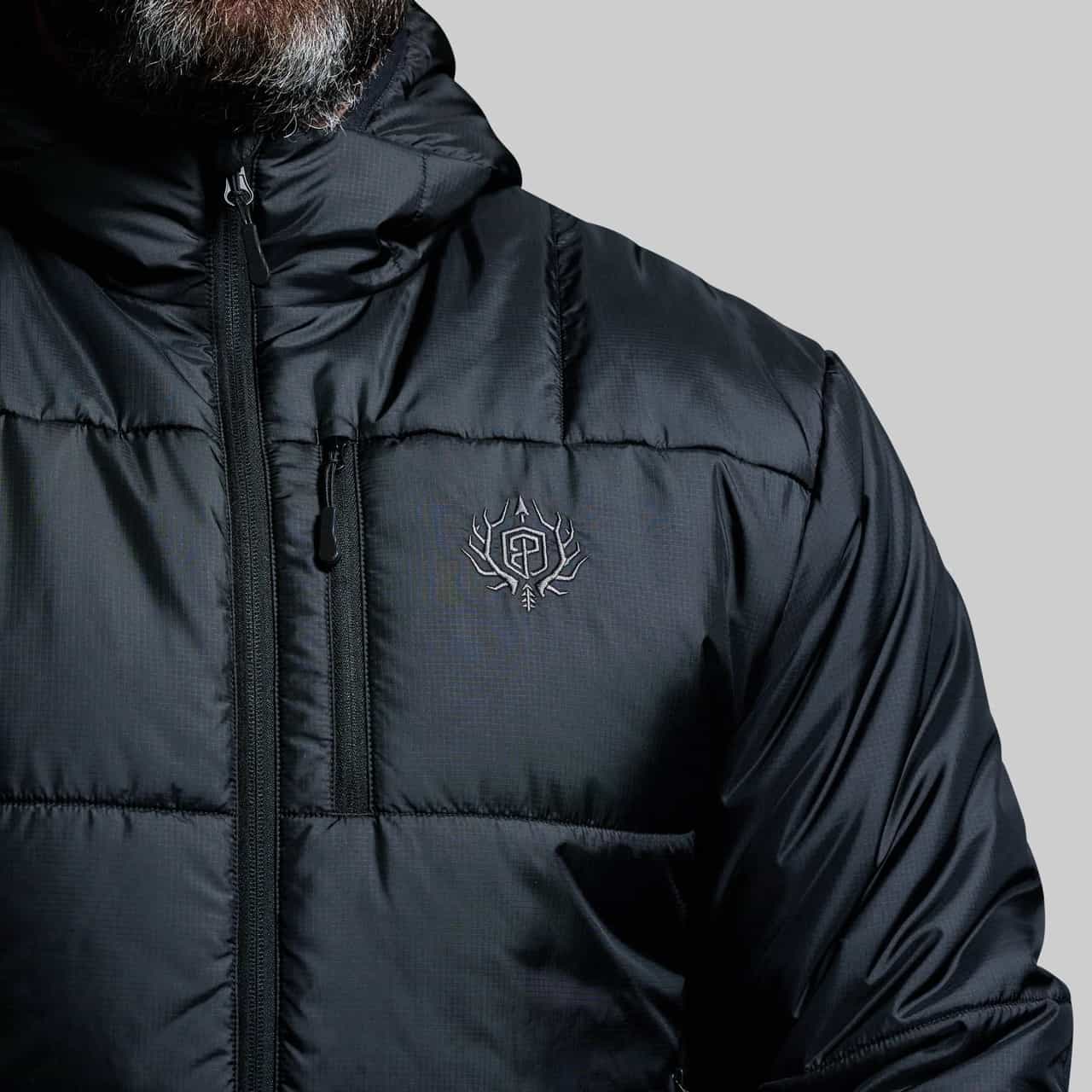 Black puffer jacket with a brand logo on a gray background
