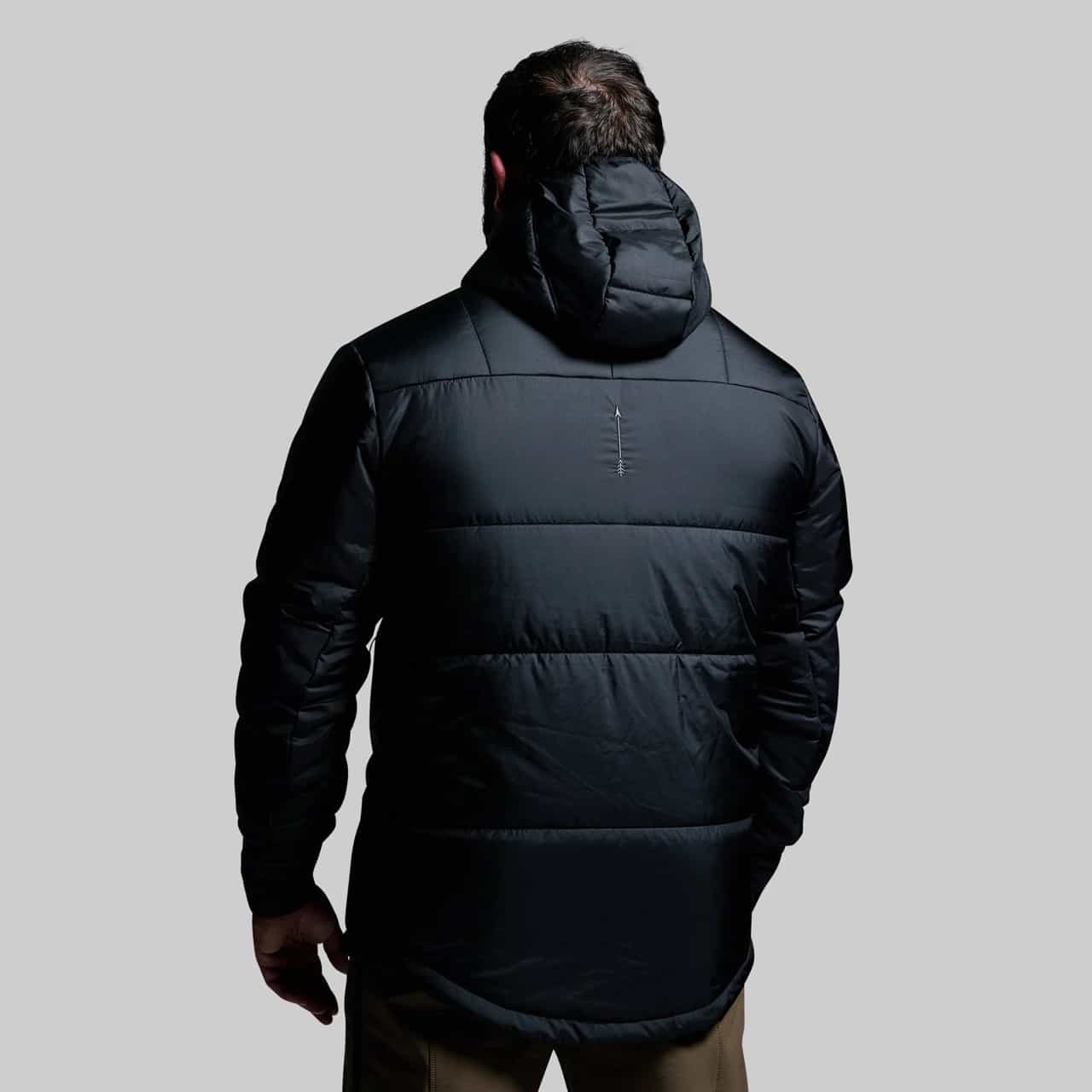 Person wearing a black puffer jacket on a gray background