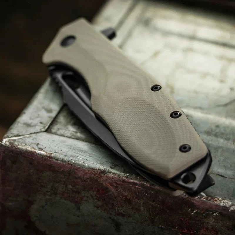 Folding knife Boker Caracal Folder Tactical close up with textured handle on a metallic surface