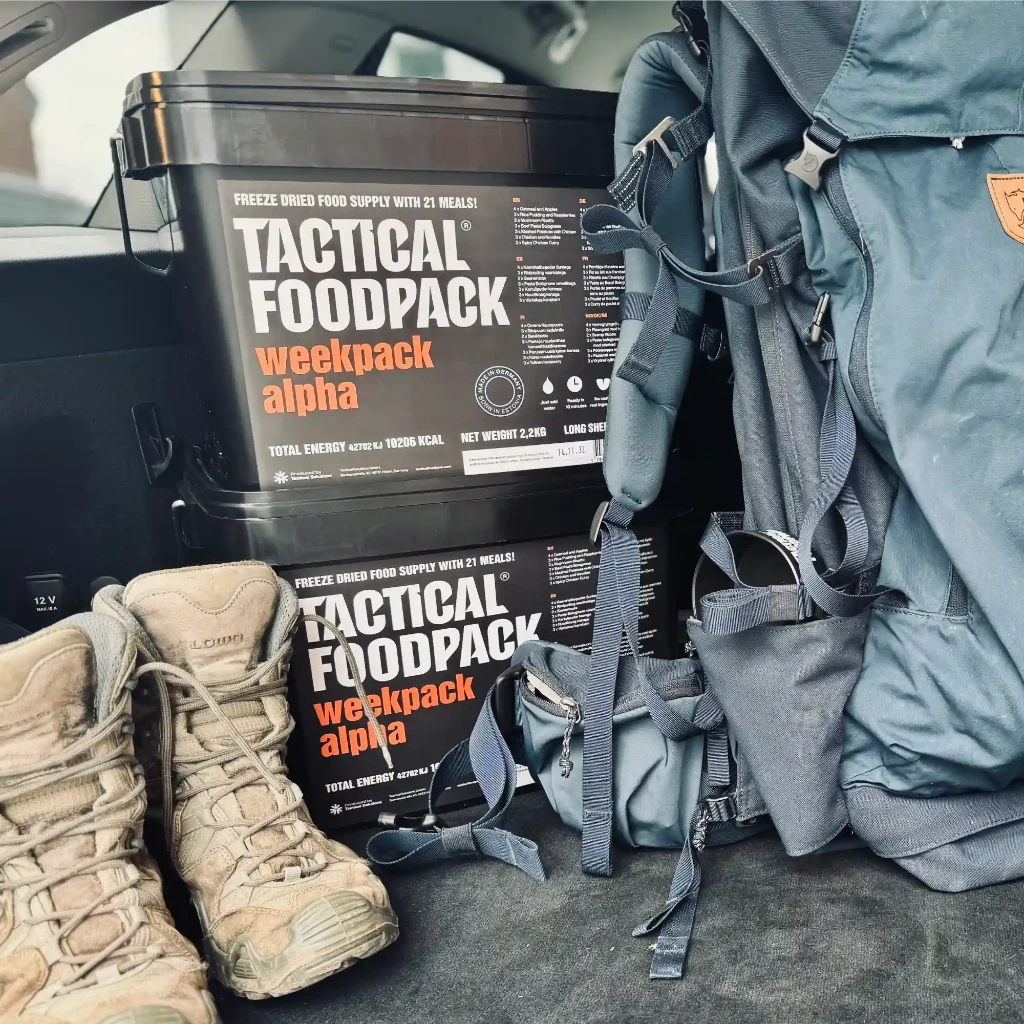 Tactical foodpack weekpack alpha container with hiking boots and backpack in a vehicle.