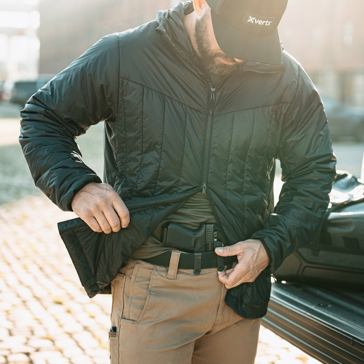 Black Vertx InBound UltraLight Puffer Jacket with two-way zipper opened for waistband access