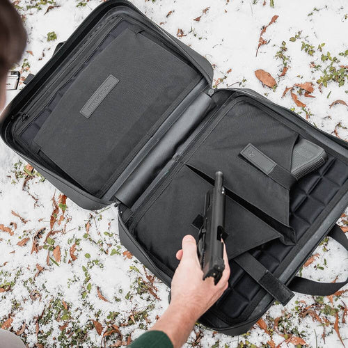 man putting a gun in a pistol bag
