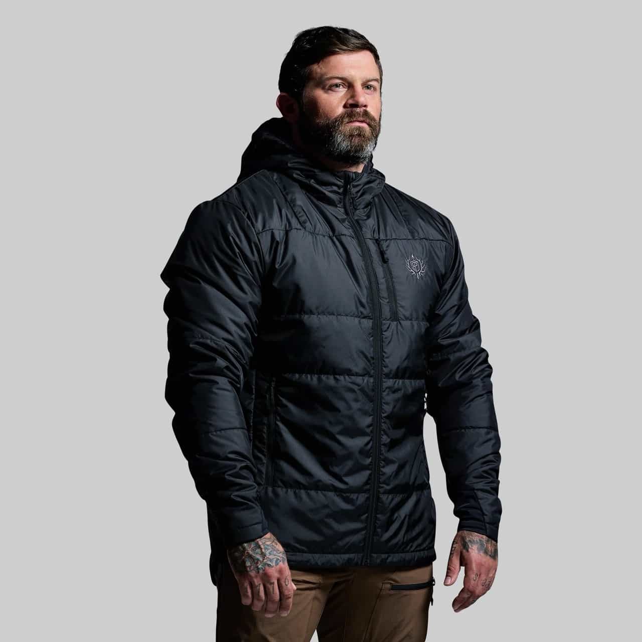 Man wearing a black puffer jacket on a gray background