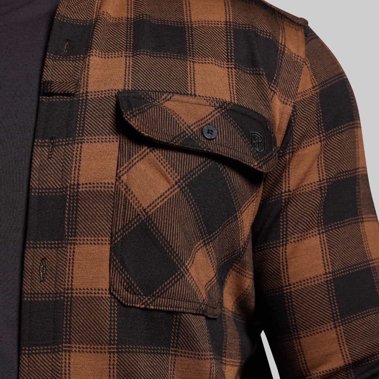 Brown and black plaid jacket with a buttoned pocket on a gray background