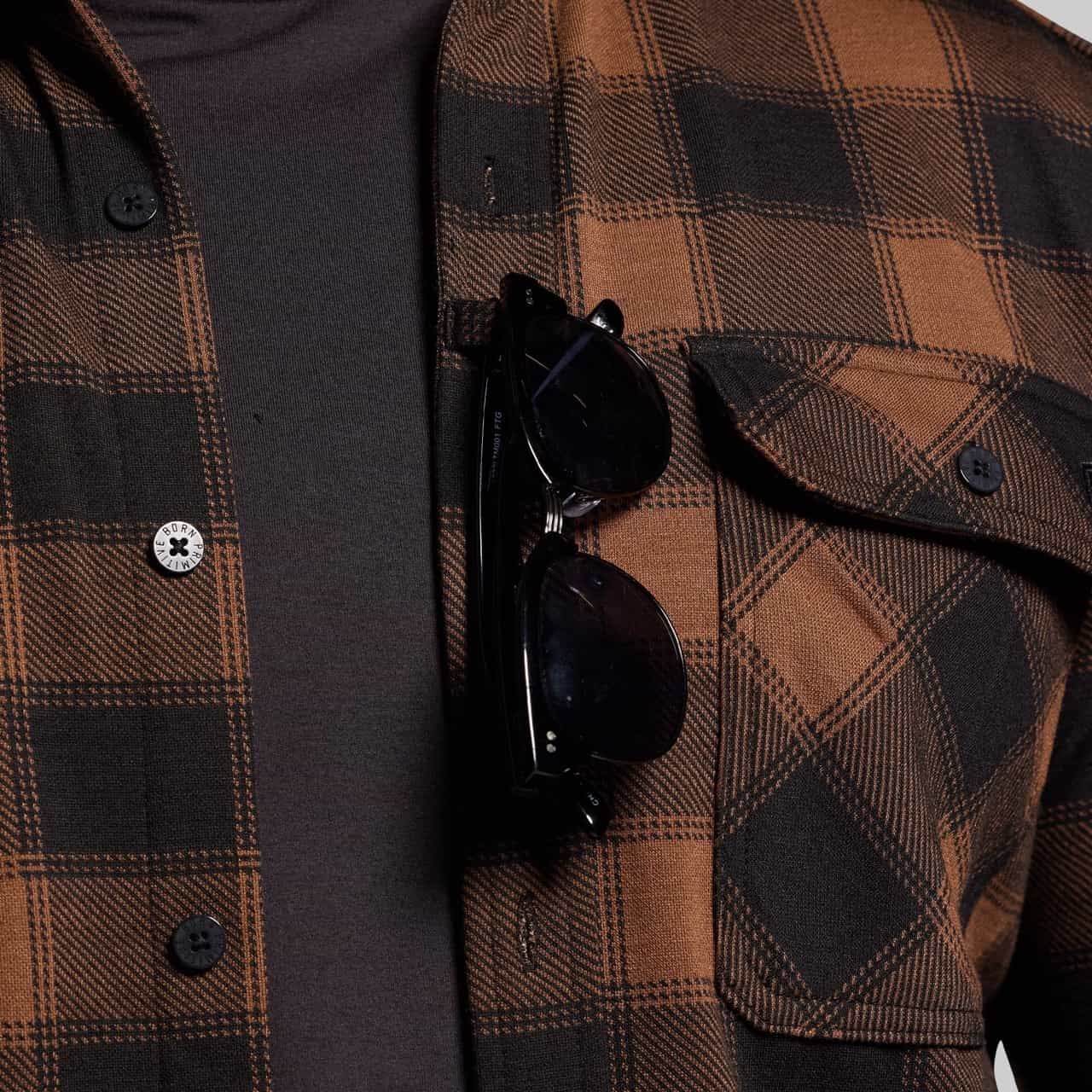Brown plaid jacket with sunglasses on a dark background