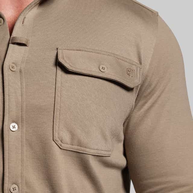 Close-up of a brown shirt with a pocket on a plain background