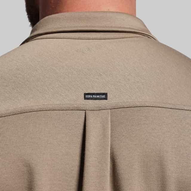 Beige shirt with a brand label on a gray background