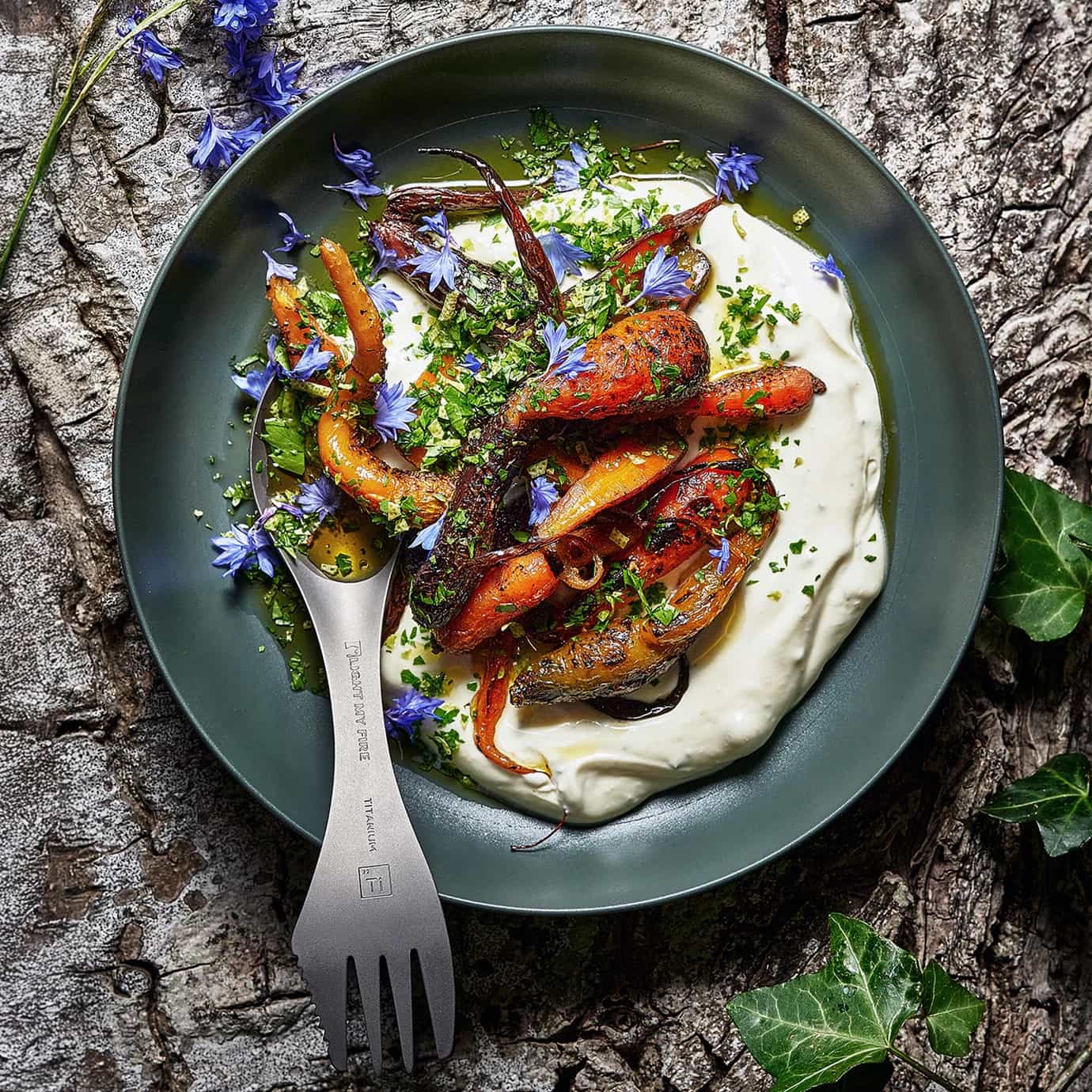 Light My Fire Swedish Spork Titanium and plated dish of roasted vegetables with a creamy base on a rustic stone surface