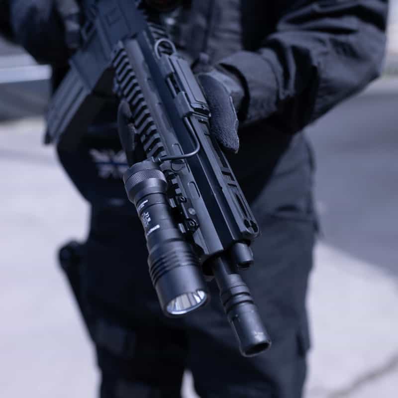 Operator with rifle and mounted Streamlight Protac Rail Mount 1L-X PRO USB weapon light close up
