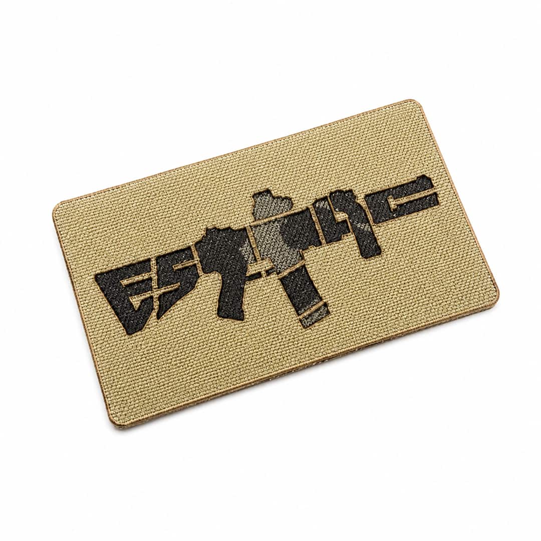 Beige ESTTAC patch with black graphic design on a white background