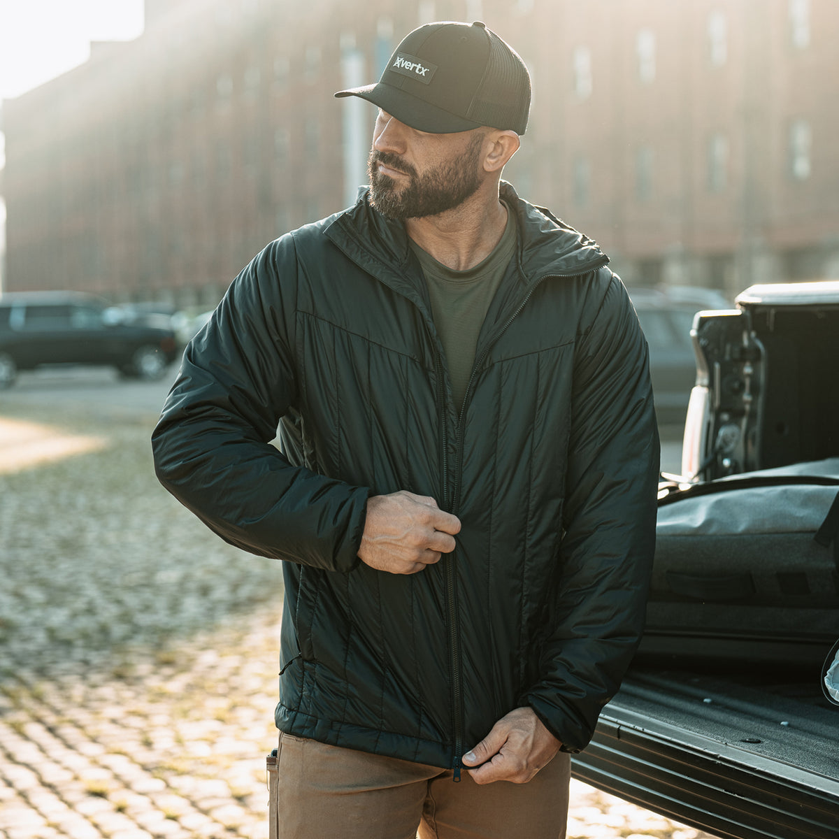 Vertx InBound UltraLight Puffer Jacket in Black worn outdoors, front three-quarter view
